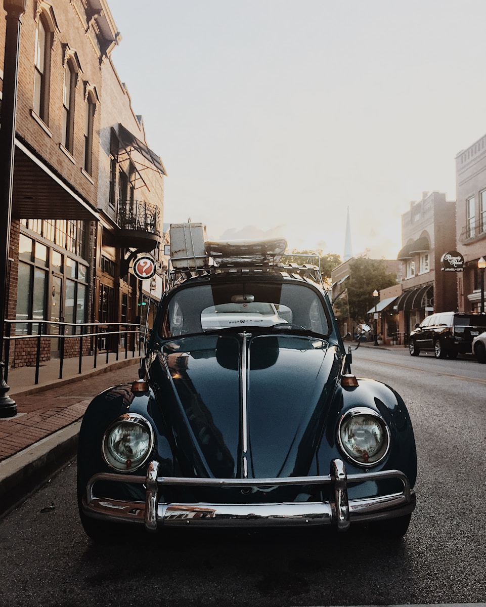 closeup photo of black Volkswagen Beetle near building with higher cost of your insurance